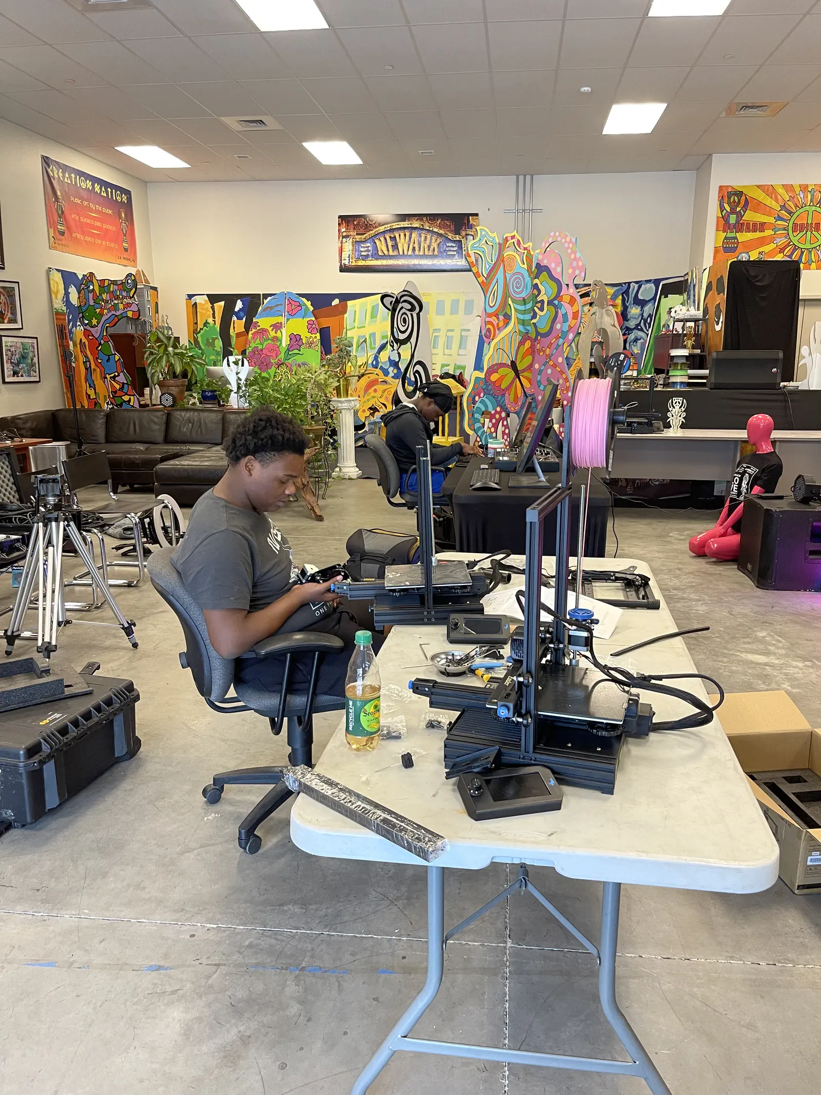 The Digi2U studio floor — printers, benches, and the mural wall